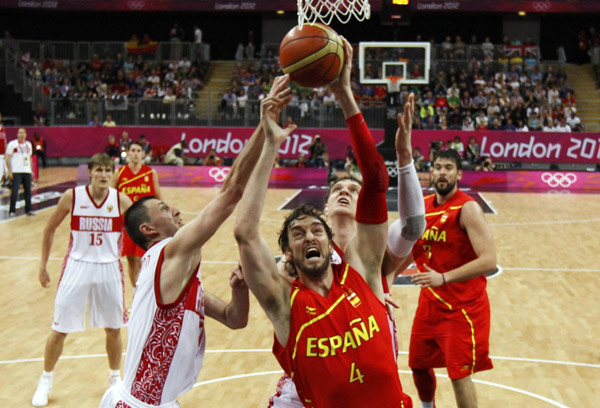 Spain's Pau Gasol grabs a rebound from Russia's Timofey Mozgov (L) during their men's basketball preliminary round, Group B match at the Basketball Arena during the London 2012 Olympic Games August 4, 2012. Russia beats Spain in men's basketball