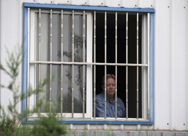 Chip Starnes, co-owner of Specialty Medical Supplies, looks out a window at the company's plant on the outskirts of Beijing, where he says he's been “kidnapped” by workers over a labor dispute, June 24, 2013. US factory boss held hostage in Beijing