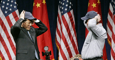 President Hu Jintao (L) puts on a Boeing baseball hat presented to him by employee Paul Demier during his visit to the plane manufacturing plant in Everett, Washington April 19, 2006.