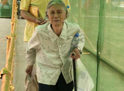 An aged woman waits to cast a vote on the demolishment and reconstruction of old buildings in Juixiaqiao Sub-district in Beijing, June 9, 2007. Local government and the real estate developer jointly organize the vote on Saturday to see if majority residents of over 5000 families accept the new compensation policy after failed attempts to reach an agreement through other ways. Both notary officials and supervisors are invited to monitor the vote that runs from 9 a.m. to 9 p.m. at six ballot booths. [Sun Yuqing/y3k9.com]