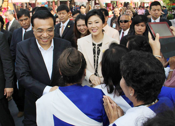 Visiting Premier Li Keqiang (left) and Thai counterpart Yingluck Shinawatra are greeted by villagers during their tour of a local products center in Chiang Mai province in northern Thailand on Sunday. Photo by Wichai Taprieu / AP Chinese education for Thai students