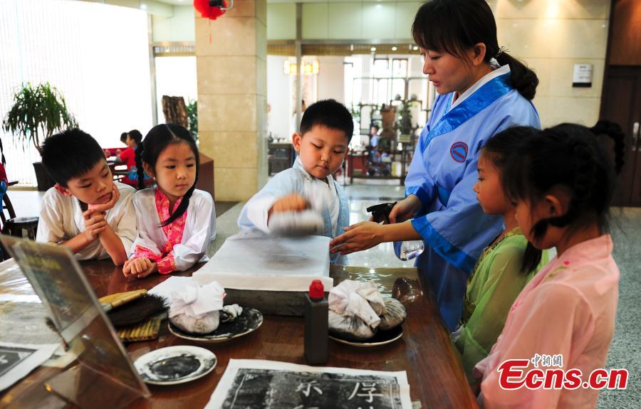 Children in traditional clothes experience classic Chinese culture