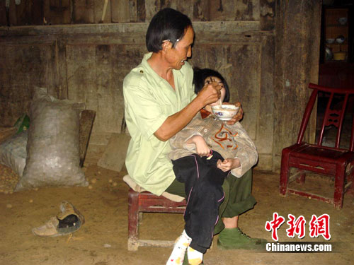 男子收養腦癱棄嬰20年 生活窘迫從未言棄（圖）