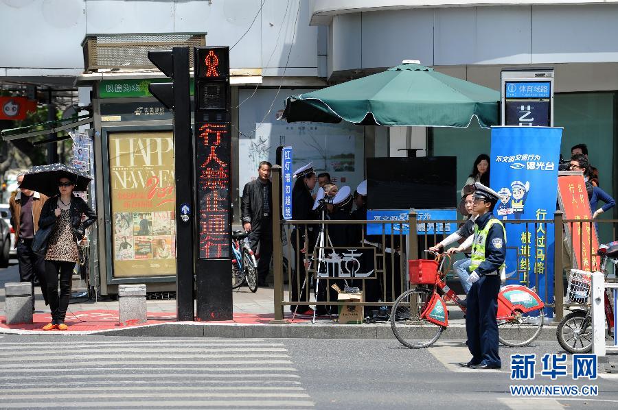 杭州新招治“中國式過馬路” 路邊擺屏幕“現場直播”