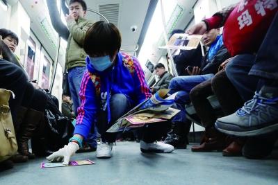 北京志愿者地鐵10號線內3小時清理廣告400斤