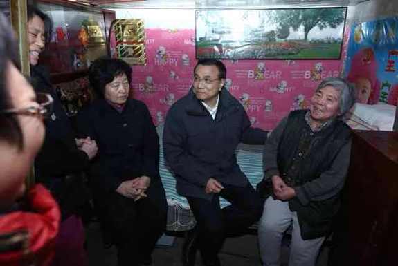 李克強考察棚戶區(qū):彎腰坐上高低床