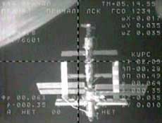 The International Space Station is visible from a black and white television camera on the Soyuz as the two crafts prepare to dock Saturday, April 16, 2005. The new ISS crew, Russian commander Sergei Krikalev and U.S. astronaut John Phillips are aboard the Soyuz capsule. European Space Agency astronaut Roberto Vittori is traveling with Kriklalev and Phillips and will return to Earth April 25th with the outgoing ISS crew. The Earth is visible in the top left side of the frame.(AP 