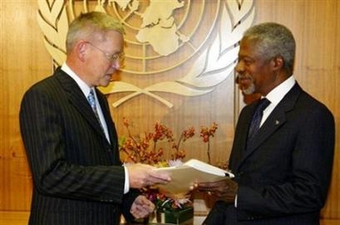United Nations (UN) International Independent Investigation Commissioner Detlev Mehlis (L) hands a report detailing the investigation into the murder of former Lebanese prime minister Rafik al-Hariri to Secretary-General Kofi Annan in New York, October 20, 2005.