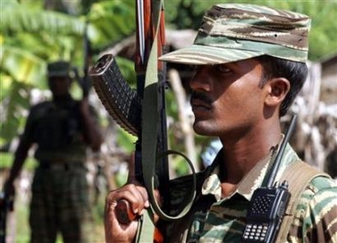 Tamil Tiger rebels hold their weapons as they keep guard outside a political office at Sampur village in Trincomalee, eastern Sri Lanka, January 20, 2006.
