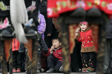 Chinese children watch performers on stilts during activities to mark Lantern Festival in Beijing February 12, 2006. Lantern Festival marks the last day of the 15-day long Spring Festival, the most important festival of the year in China.