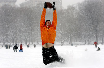 A man plays a game of football during a snowstorm in New York's Central Park, February 12, 2006. The biggest snowstorm of the season belted the northeastern United States on Sunday shutting airports, snarling traffic and bringing joy to ski resorts. As much as 22.8 inches (57.9 cm) of snow fell in New York's Central Park, the second heaviest snowfall on record, topped only by a blizzard in 1947, according to the National Weather Service.