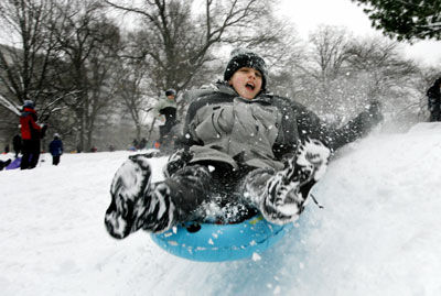 A boy goes sledding in New York's Central Park during a snowstorm February 12, 2006. The biggest snowstorm of the season belted the northeastern United States on Sunday with whiteout conditions and flashes of lightning, forcing airports to close, snarling traffic and bringing joy to ski resorts. As much as 22.8 inches (57.9 cm) of snow fell in New York's central park, the second heaviest snowfall on record, topped only by a blizzard in 1947, said the National Weather Service.