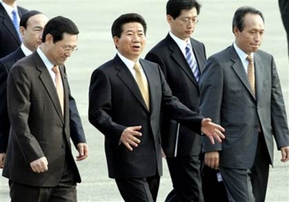 South Korean President Roh Moo-hyun, center, talks with unidentified government officers as he leaves for Beijing at Seoul Military Airport Friday, Oct. 13, 2006. South Korean President Roh Moo-hyun and Chinese President Hu Jintao are scheduled to hold a summit in Beijing on Friday to to find a response to Pyongyang's nuclear test. [AP]