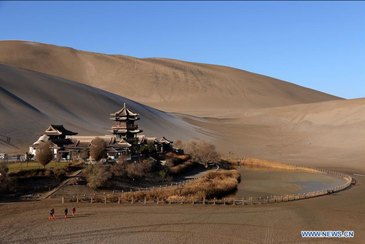 Tourists visit crescent spring of Mingsha Hill in Dunhuang