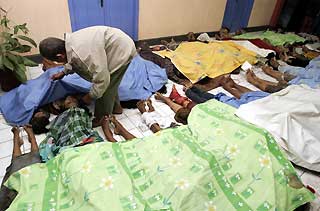 An Indonesian survivor searches for his relatives among 41 bodies at Pangandaran public health centre in West Java July 18, 2006.