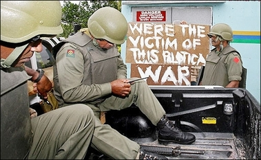 A protester holds up a sign for soldiers to read outside the Prime Ministers residence before Fiji's military head Voreqe Bainimarama announced it had toppled the government and dismissed elected Prime Minister Laisenia Qarase, in Suva. Fiji's political leaders criticised the coup by military commander Voreqe Bainimarama but media censorship by the armed forces meant many Fijians did not hear their condemnations.(AFP