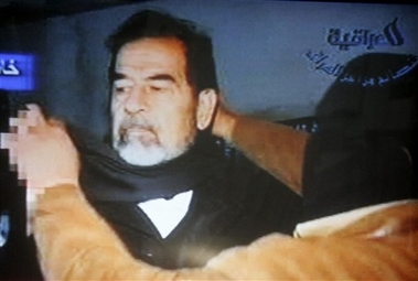 This video image released by Iraqi state television shows Saddam Hussein being led to the gallows by guards wearing ski masks moments before his execution Saturday Dec. 30. 2006. Clutching a Quran and refusing a hood, Saddam Hussein went to the gallows before sunrise Saturday, executed by vengeful countrymen after a quarter-century of remorseless brutality that killed countless thousands and led Iraq into disastrous wars against the United States and Iran. (AP