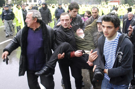 Opposition supporters carry their friend during a clash with police at a demonstration in central Tbilisi Nov. 7, 2007.