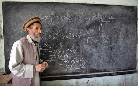 Afghan school continues as soldiers guard aside