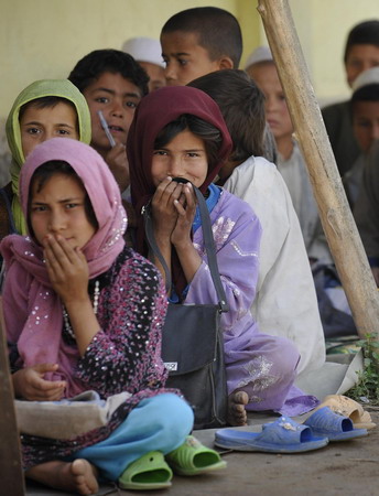 Afghan school continues as soldiers guard aside