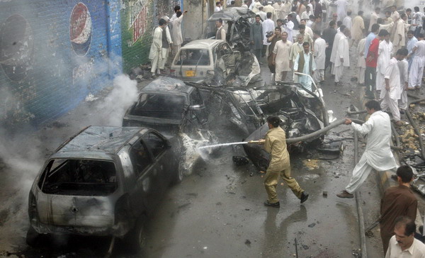 Firefighters spray water on damaged vehicles at the site of a car bomb blast in Quetta August 31, 2011. Suspected suicide bombing kills 10 in Pakistan