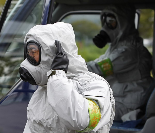 Tokyo Metropolitan Police Department officers wearing chemical protective gear take part in an earthquake disaster drill in Tokyo Sept 1, 2011. Japan disaster drills hold greater sense of urgency