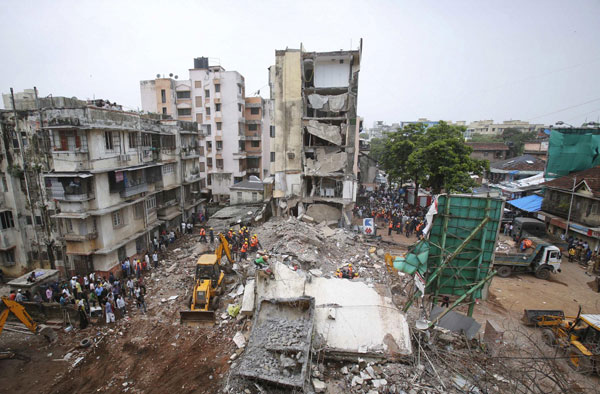 Rescue workers search for survivors trapped under the debris at the site of a collapsed residential building in central Mumbai June 11, 2013. Mumbai building collapse kills 5