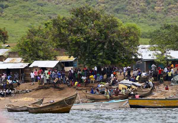A general view shows the landing site where retrieved bodies are gathered after a boat carrying mostly Congolese refugees capsized at the shores of Lake Albert during rescue operations by the Uganda Marine Unit in Ntoroko southwest of Uganda's capital Kampala, March 23, 2014. 19 dead, 32 missing in Uganda boat accident