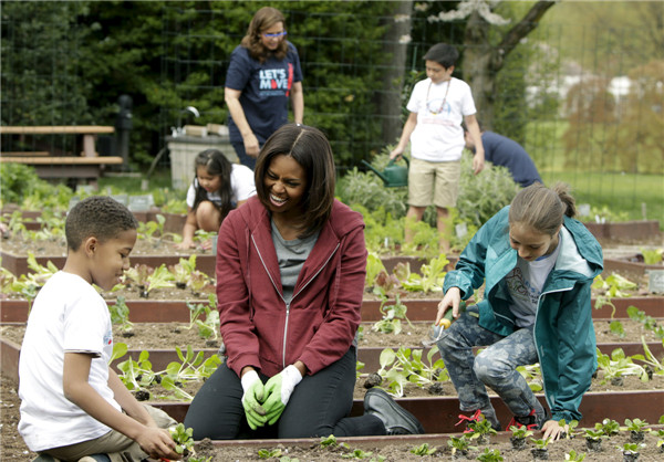 Michelle Obama plants vegetables with school children